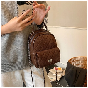 Détail du sac à dos matelassé en velours marron avec chaîne en argent et boucle à fermoir rotatif