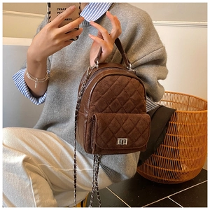Détail d'un mini sac à dos matelassé marron foncé avec velours et chaîne argentée