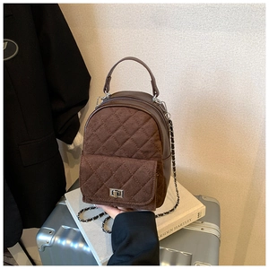 Détail du sac en daim matelassé marron foncé avec fermoir rotatif et bandoulière chaîne