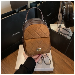 Détail du sac matelassé marron avec bandoulière chaîne et fermoir rotatif sur boîte