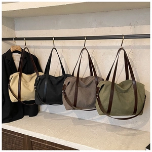 Detalle de bolsos tote de lona multicolor con asas de cuero y bolsillos laterales