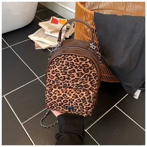 Détail d'un mini sac à dos à imprimé léopard avec matelassage et chaîne argentée