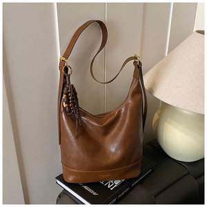 Detalle del bolso hobo de cuero sintético marrón con adorno de cuentas de madera vintage