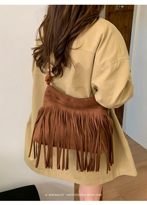 Detailed view of dark brown suede tassel shoulder bag with retro bohemian knot strap