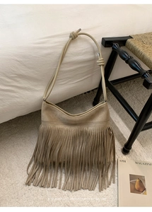 Detailed view of the boho suede fringe bag with unique knotted shoulder strap design