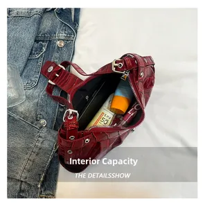 Interior view showing the capacity of dark red crocodile pattern crescent bag with essentials