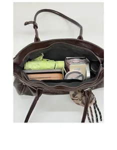 Interior view showing large capacity and compartments of the brown tote bag with daily items