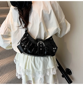 Detail of crocodile embossed leather shoulder bag with silver studs and metal buckles