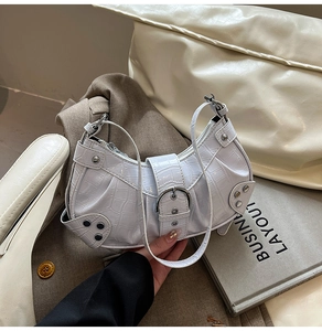 Detail of white crocodile pattern hobo bag with silver rivet studs and metal buckle