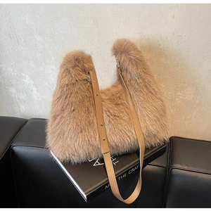 Detail shot of plush faux fur texture on a light brown shoulder bag with leather strap