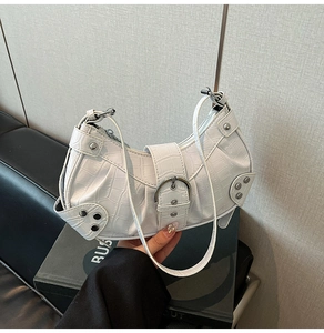 Close-up of white crocodile pattern hobo bag with silver rivets and metal hardware