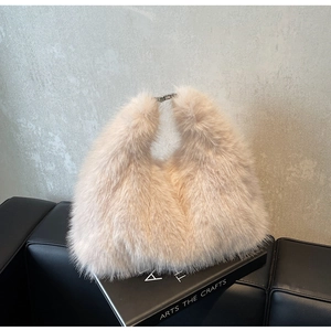 Detailed macro of plush faux fur texture and silver metal clasp on a cream handbag
