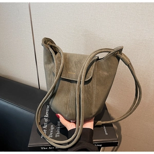 Détail du sac seau vert olive en cuir grainé avec inscription FASHION dorée