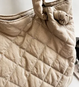 Détail du sac fourre-tout matelassé kaki montrant le tissu doux et le nœud décor