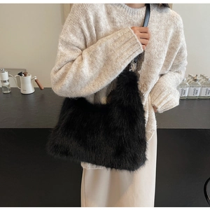 Detail shot of black faux fur shoulder bag with leather strap and silver metal buckles