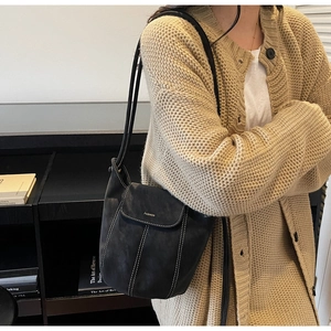 Détail d'un sac à épaule en cuir noir avec surpiqûres blanches et logo de mode élégant