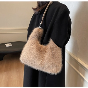 Detail of plush faux fur shoulder bag with leather strap on black wool coat