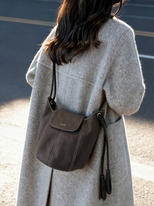 Sac seau en daim marron minimaliste avec coutures contrastées et détail de pompon