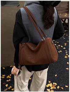 Detail of a large vintage brown faux suede tote bag with dual straps in an autumn setting