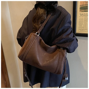 Detail view of deep brown vintage tote bag with distressed leather and silver padlock