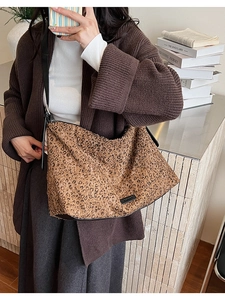 Détail du sac cabas léopard avec strass étincelants et finitions en cuir noir