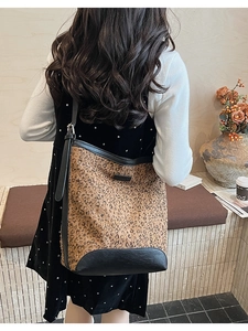 Dettaglio della borsa a secchiello leopardata con cinturino in pelle nera e glitter
