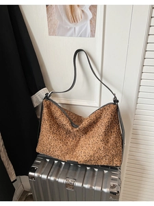 Détail du sac hobo avec paillettes léopard marron et lanières en cuir noir chic