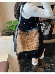 Borsa a secchiello leopardata con cinturini in pelle nera in un ambiente interno elegante