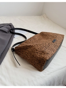 Gros plan détaillé du motif léopard et des finitions en cuir noir sur un sac cabas