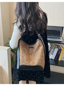 Dettaglio della borsa a secchiello leopardata con finiture in pelle e tracolla regolabile