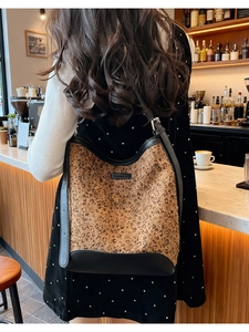 Dettaglio della borsa a secchiello leopardata con paillettes e tracolla in pelle nera
