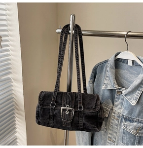 Gros plan du sac bandoulière vintage en jean noir délavé avec boucles métalliques argent