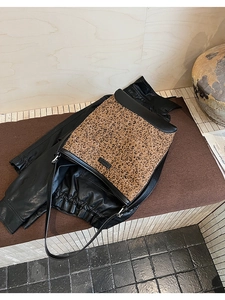 Dettaglio della borsa a secchiello leopardata con finiture in pelle nera e logo vintage