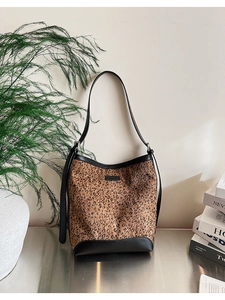 Dettaglio della borsa a secchiello leopardata con cuciture in pelle nera su base argento