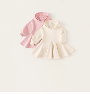 Détail de robes à capuche en coton rose et crème avec ourlets à volants pour petites filles