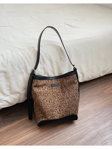 Dettaglio della borsa hobo leopardata con finiture in pelle nera e tracolla regolabile