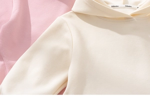 Détail du tissu gaufré et du col côtelé sur les robes à capuche pour filles