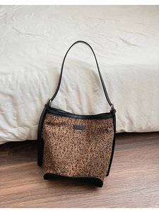 Dettaglio della borsa a secchiello leopardata con tessuto strutturato e rifiniture in pelle