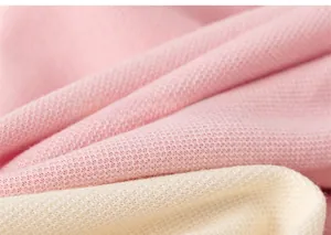 Gros plan détaillé de la texture du tissu en maille rose et beige pour robe de fille