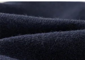 Gros plan macro montrant la texture tricotée bleu marine et le fil fin du cardigan