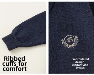Détail du cardigan en maille bleu marine avec poignets côtelés et écusson brodé élégant