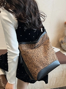 Borsa a secchiello leopardata con finiture in pelle nera indossata a spalla elegante