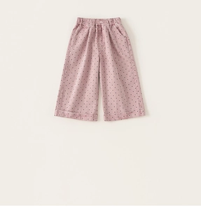 Close-up of pink girls' wide-leg trousers with black polka dots and elastic high waist