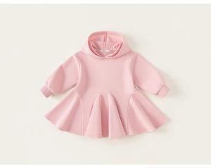 Détail d'une robe à capuche rose en coton avec ourlet à volants et finitions soignées