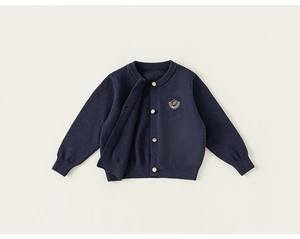 Détail du cardigan en tricot bleu marine pour garçons avec boutons dorés et broderie