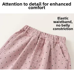 Detail of pink polka dot pants showing elastic waistband and decorative buttons