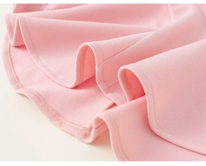 Gros plan sur la texture du tissu en maille piquée rose et coutures de robe pour filles