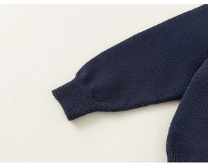 Détail de la manche du pull en maille bleu marine avec poignets côtelés et texture fine