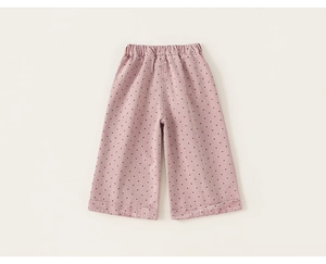 Detail of pink polka dot girls trousers showing elastic waist and rolled hem finish