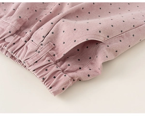 Close-up of pink polka dot girls cotton pants showing elastic waist and button details